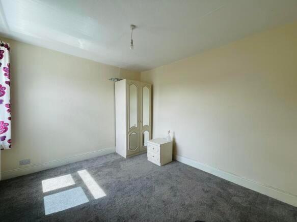 A bright double bedroom featuring a large windo...