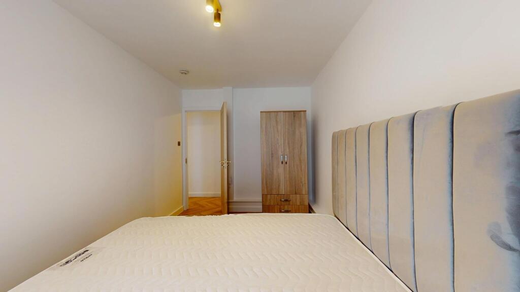 A neat and tidy single bedroom featuring a comf...