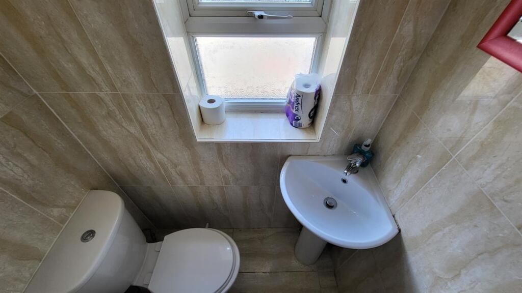 A neat and tidy single toilet space featuring a...