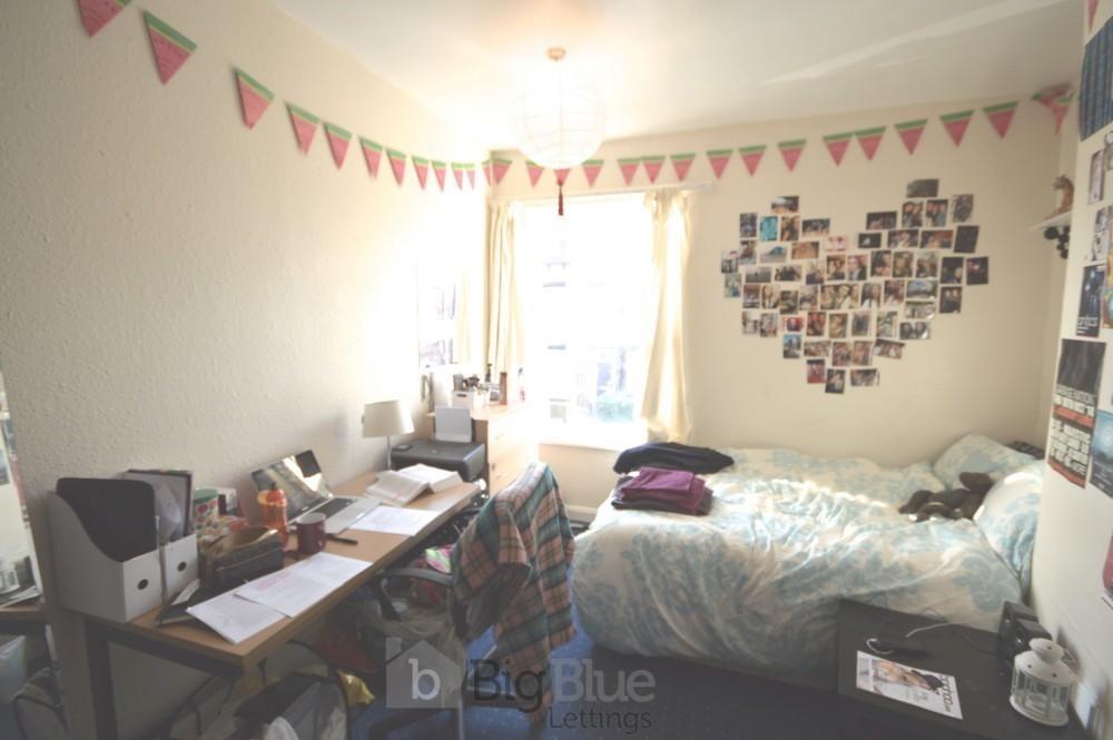 A cozy single bedroom featuring a neatly made b...