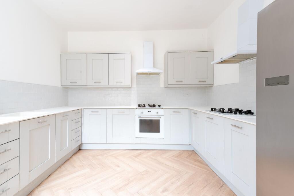 Bright and modern kitchen with extensive white ...