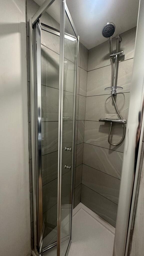 A modern and tidy bathroom shower area featurin...