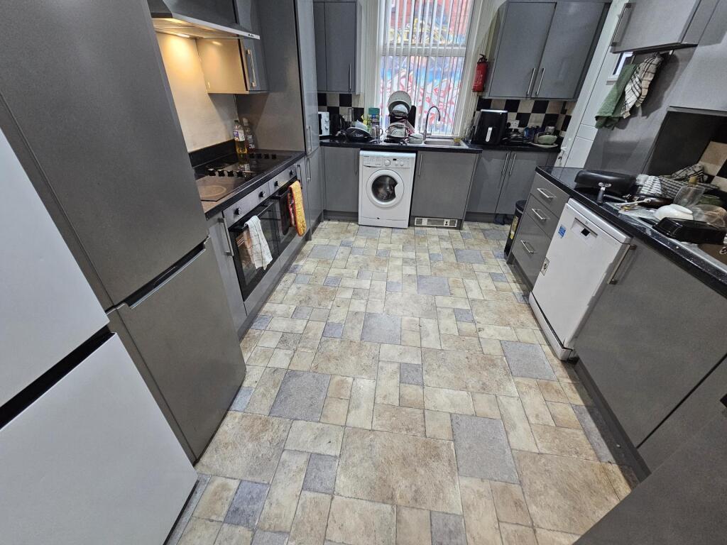 Modern kitchen with sleek grey cabinets, a vari...