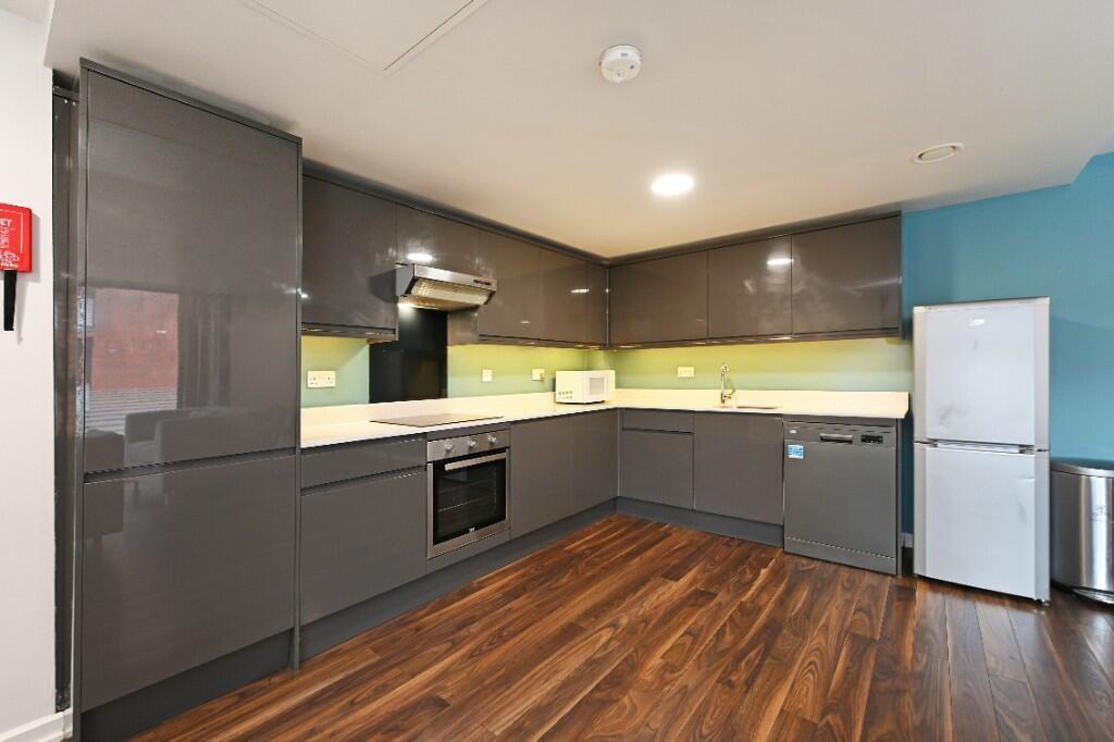 Modern kitchen featuring sleek grey cabinetry, ...