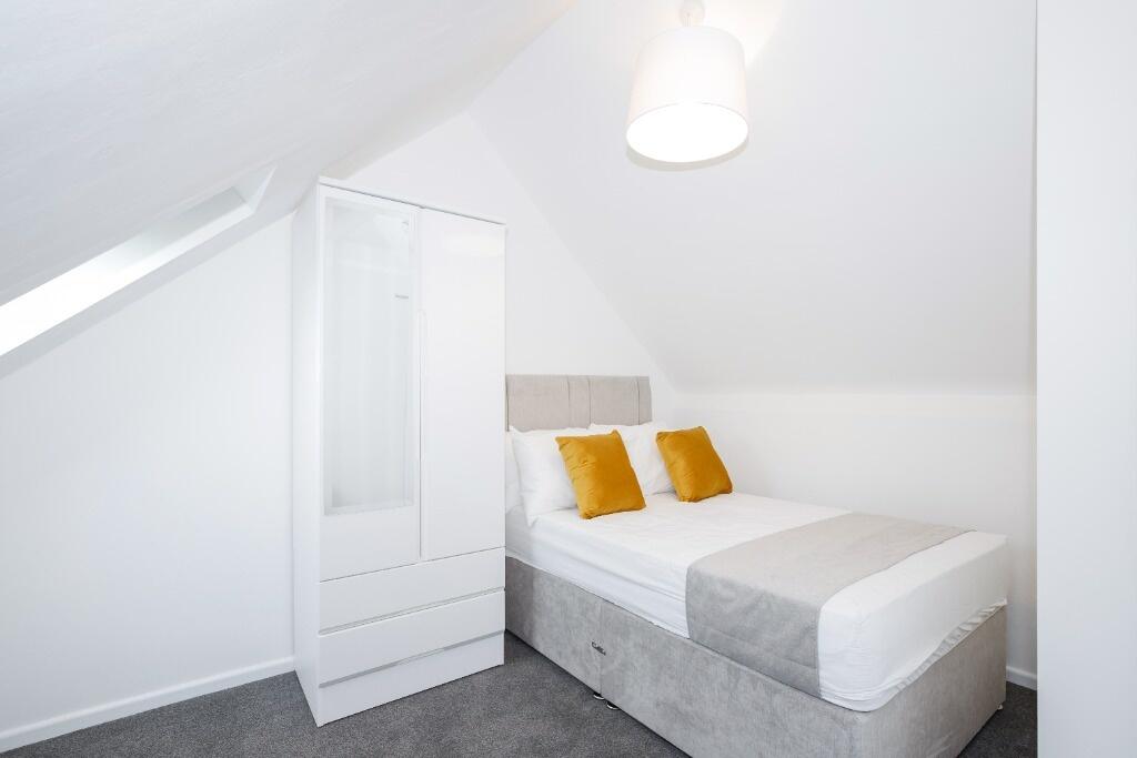 This stylish double bedroom features a comforta...