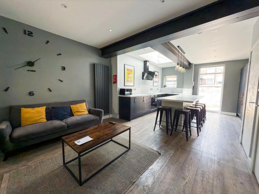 A modern, well-lit living room featuring a comf...