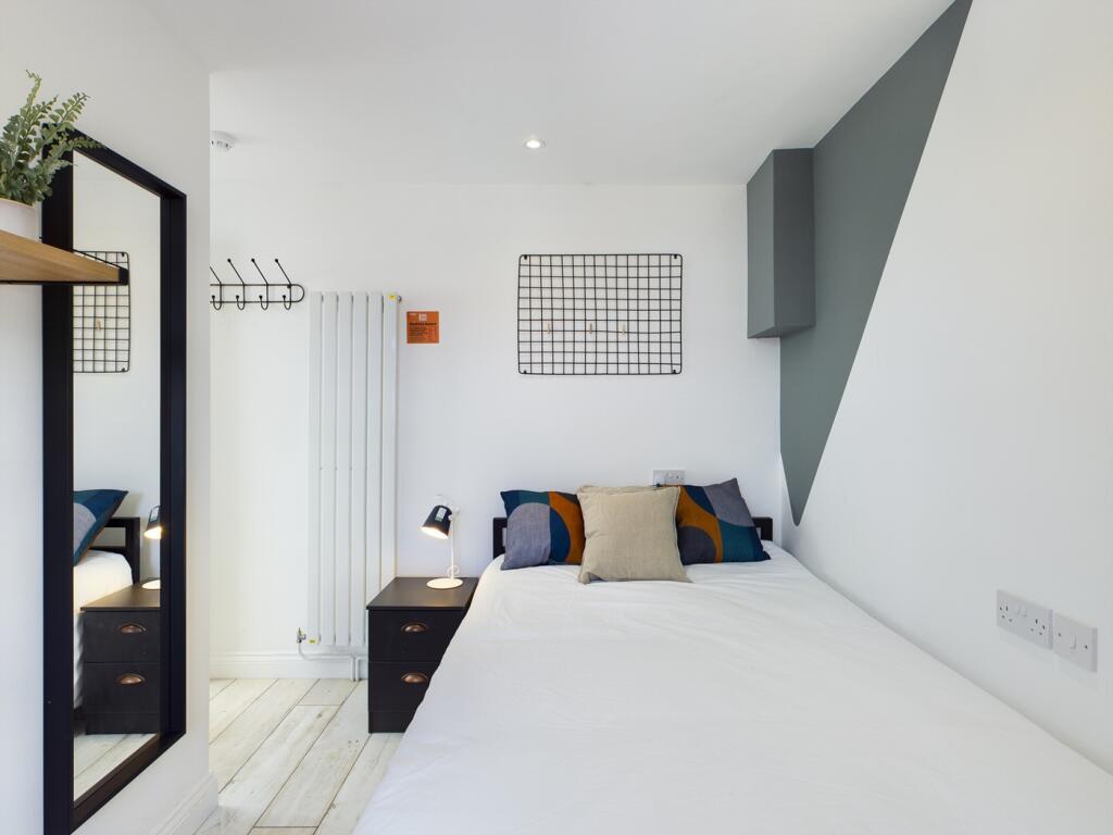 A bright and tidy double bedroom featuring mode...