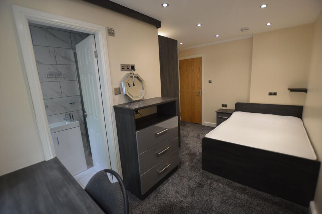 A neatly presented bedroom featuring a large be...