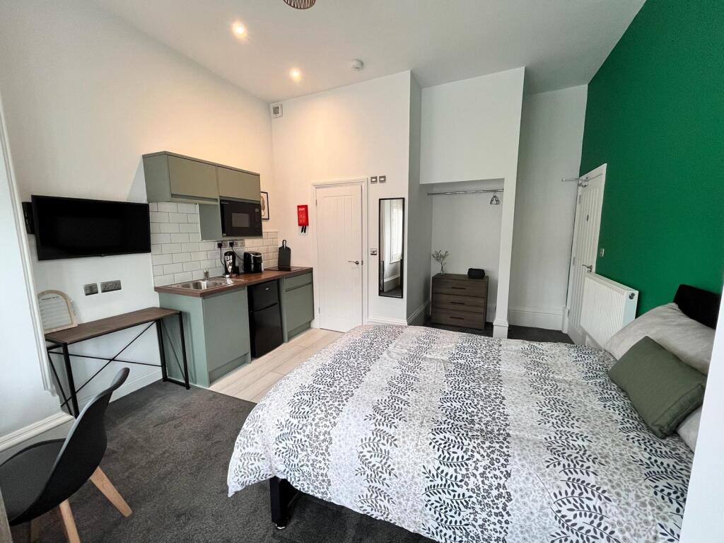 This inviting double bedroom features a modern ...