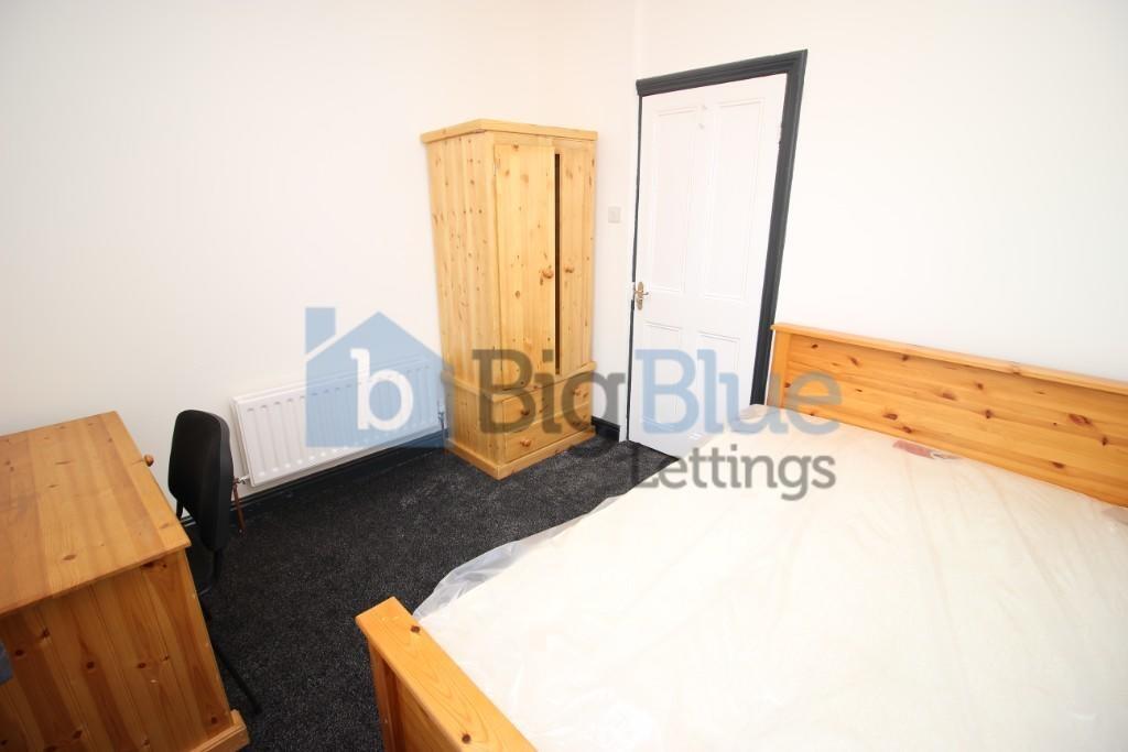 A cozy and well-kept bedroom featuring a wooden...