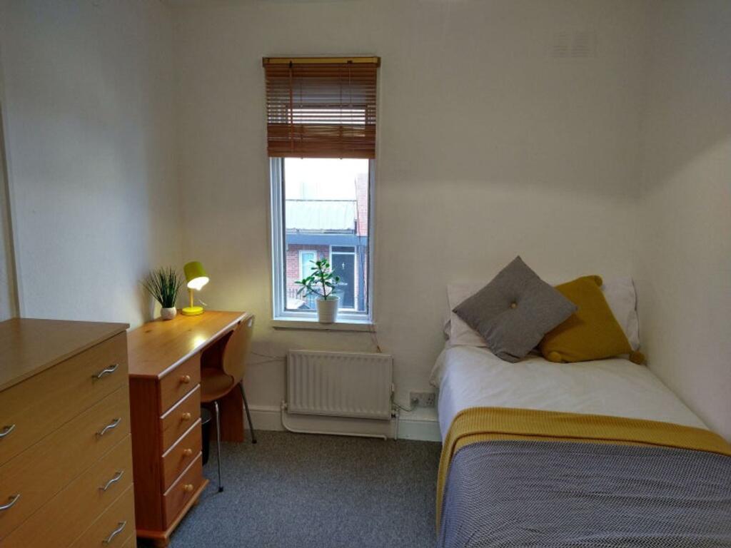 This cozy double bedroom features a comfortable...