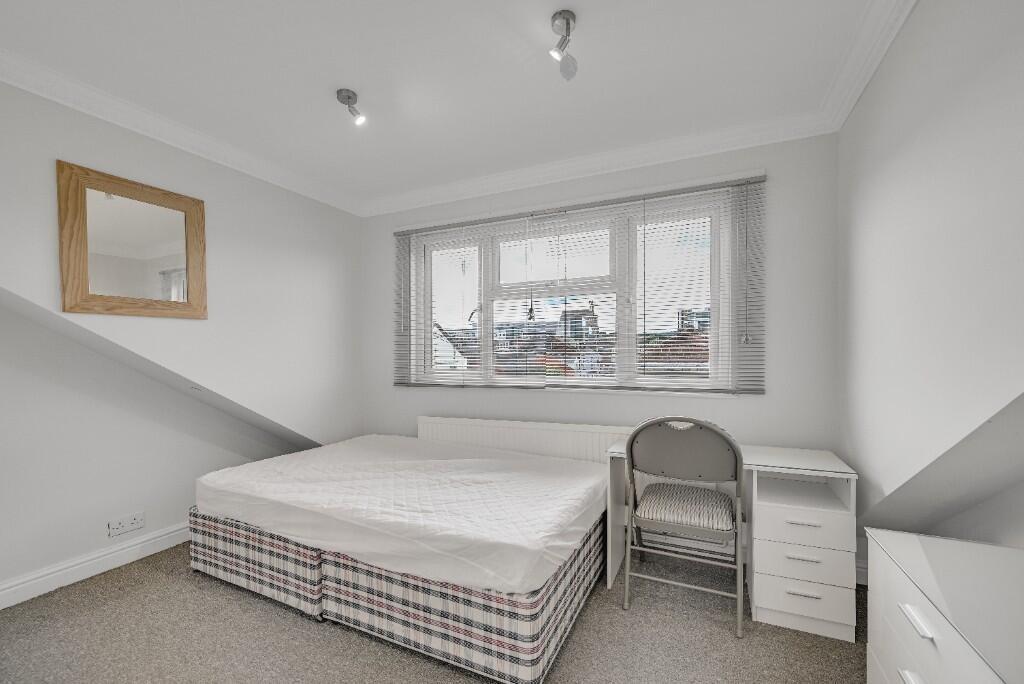 A bright double bedroom featuring a comfortable...
