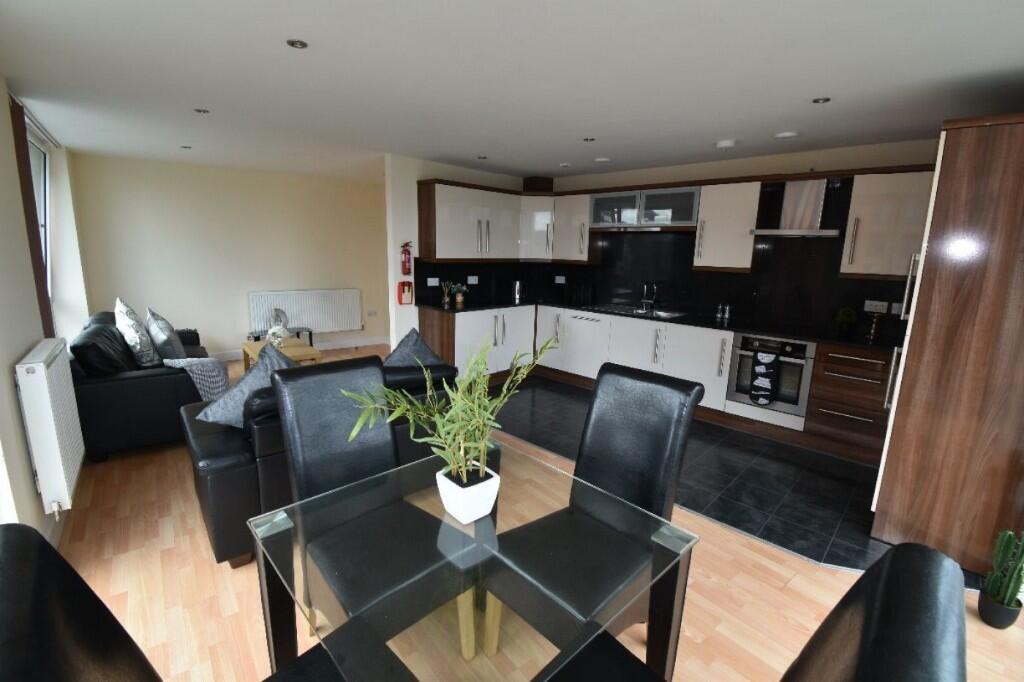 A modern open-plan living area featuring a blac...