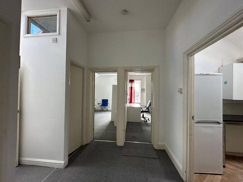 A clean and well-lit hallway featuring multiple...