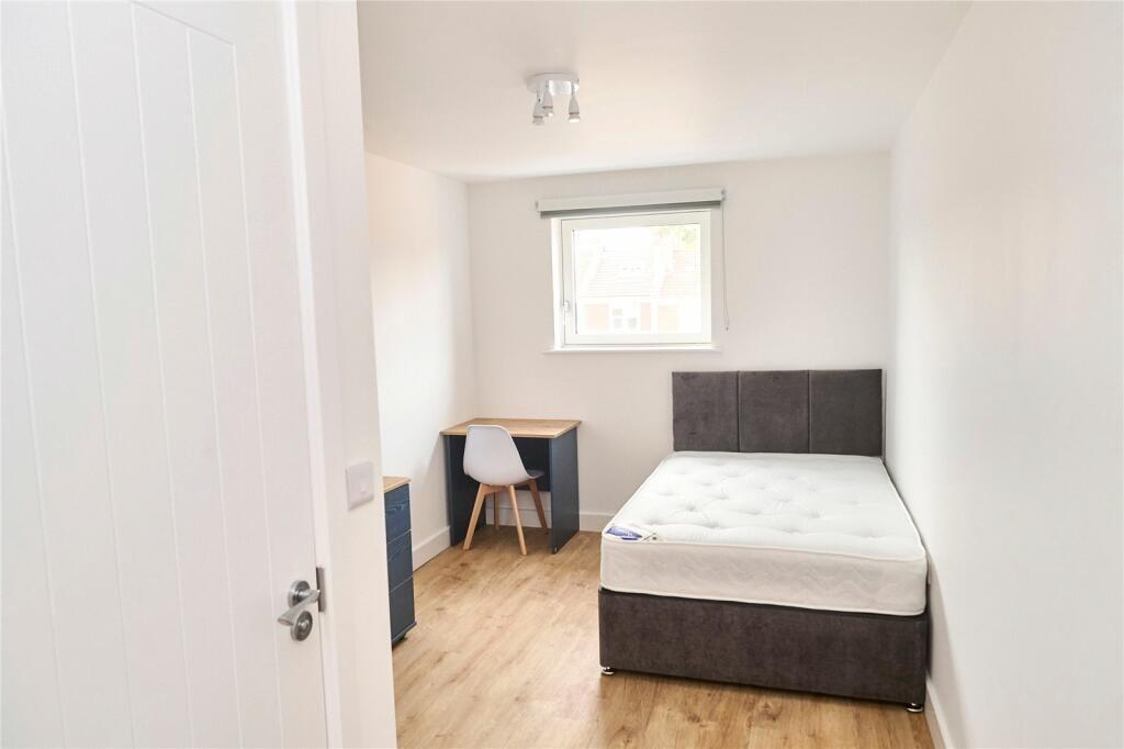 A clean and bright double bedroom featuring a c...