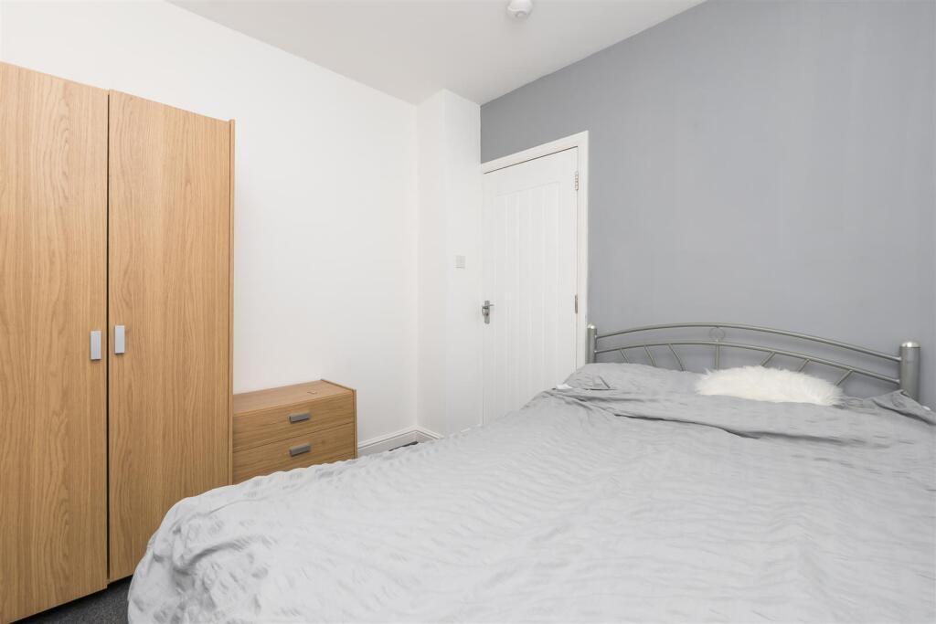 A cozy double bedroom featuring a neatly made b...