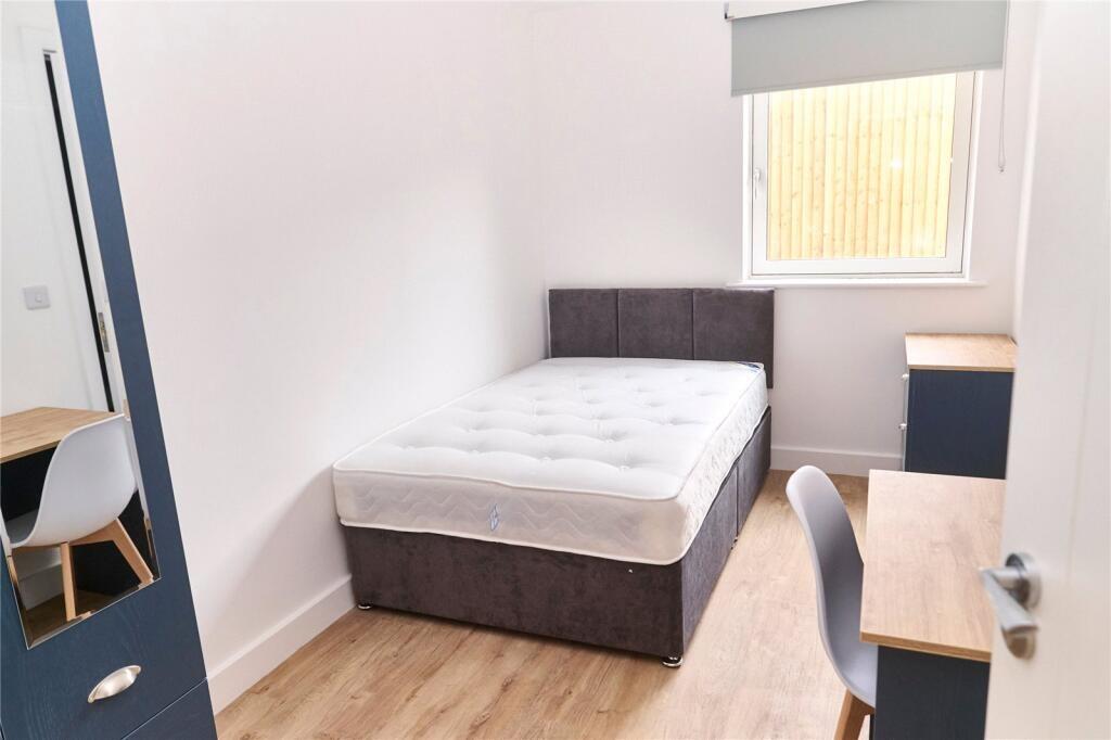 A bright and tidy single bedroom featuring a co...