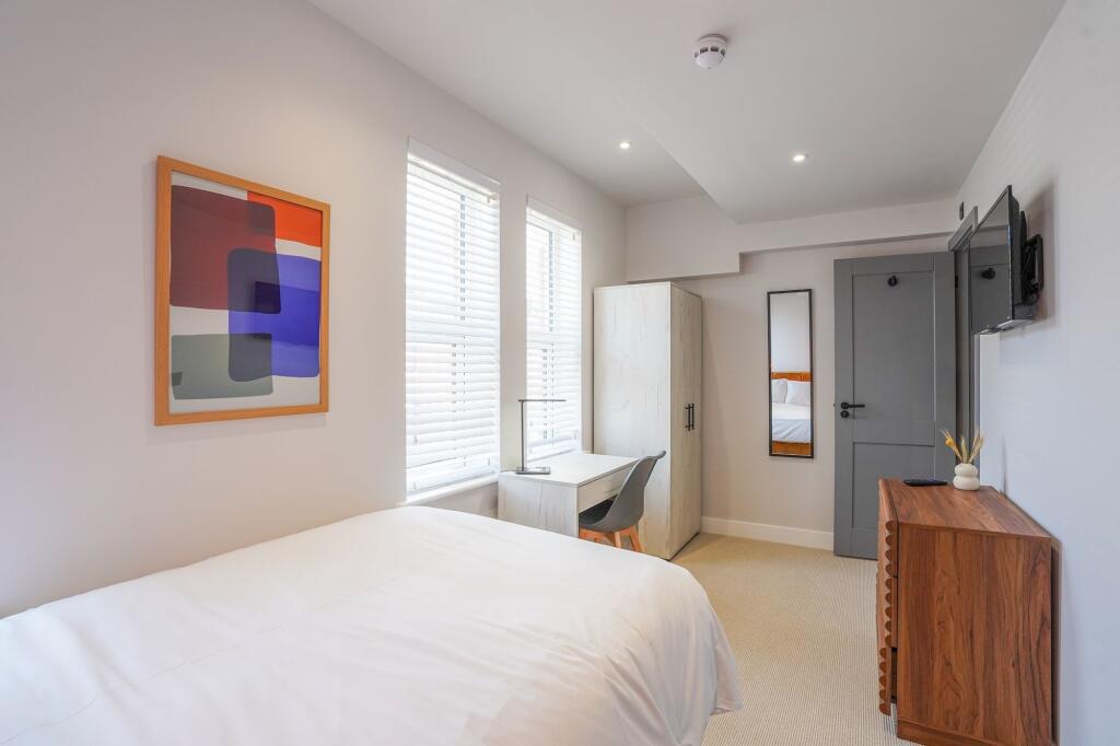 A bright and modern bedroom with large windows ...