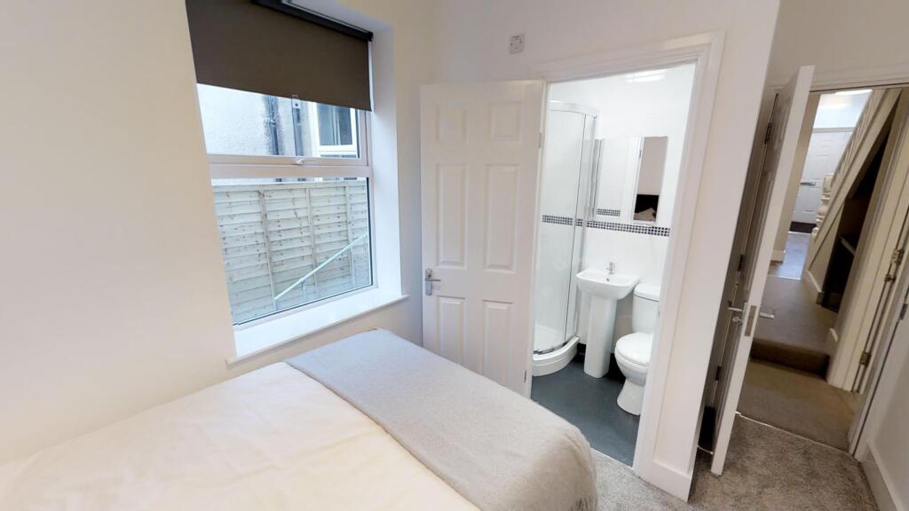 Bright and clean double bedroom featuring a com...