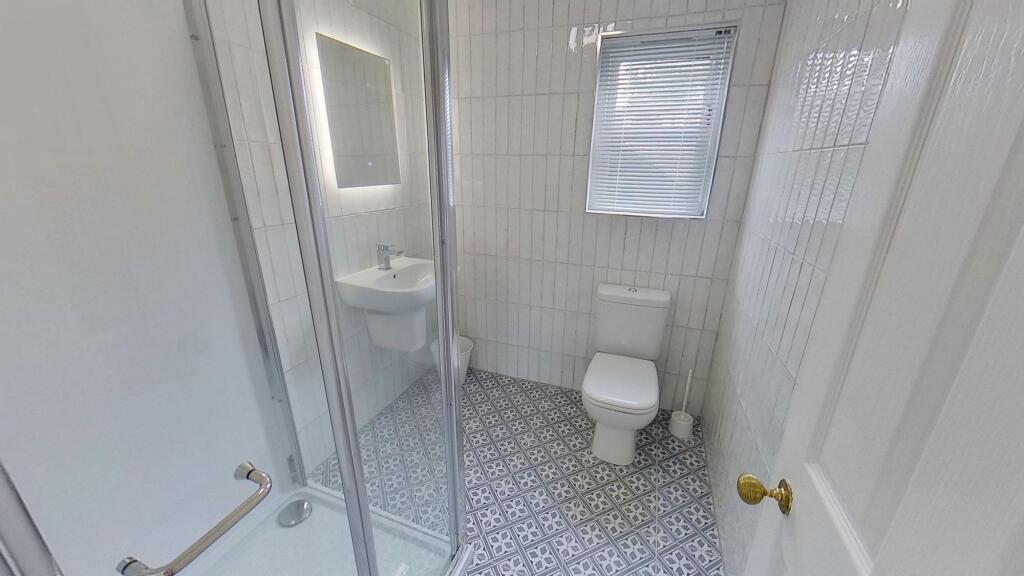 Bright and clean bathroom with a shower enclosu...