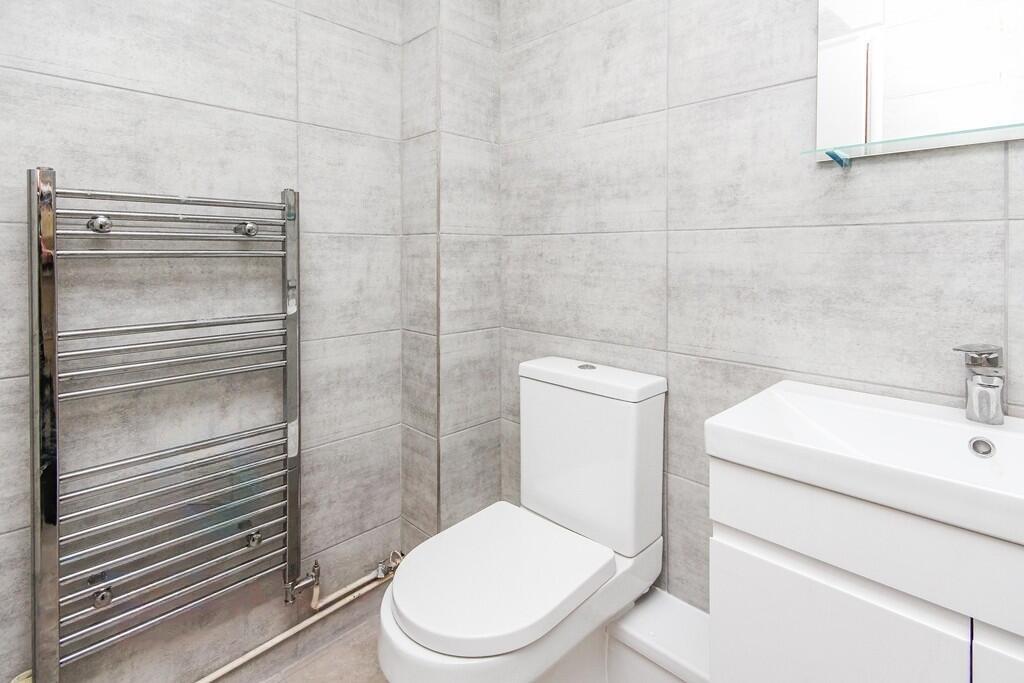 Modern, clean bathroom featuring a sleek toilet...