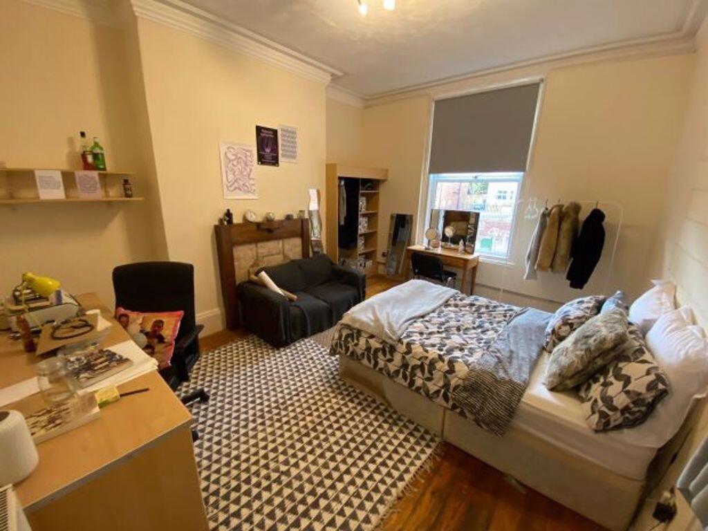 A cozy double bedroom featuring two beds, a des...