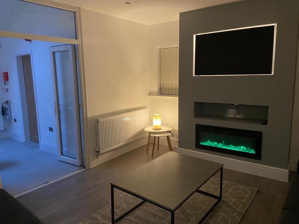 Contemporary living room with a wall-mounted di...