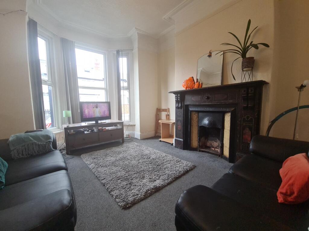 A cozy living room featuring a classic fireplac...