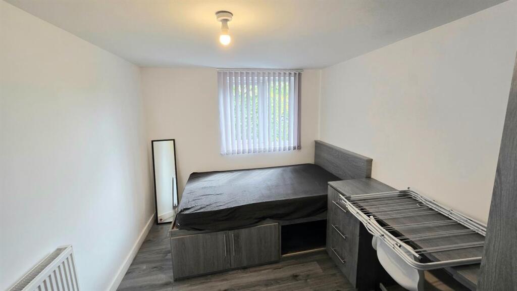 Bright, simply furnished bedroom with a double ...