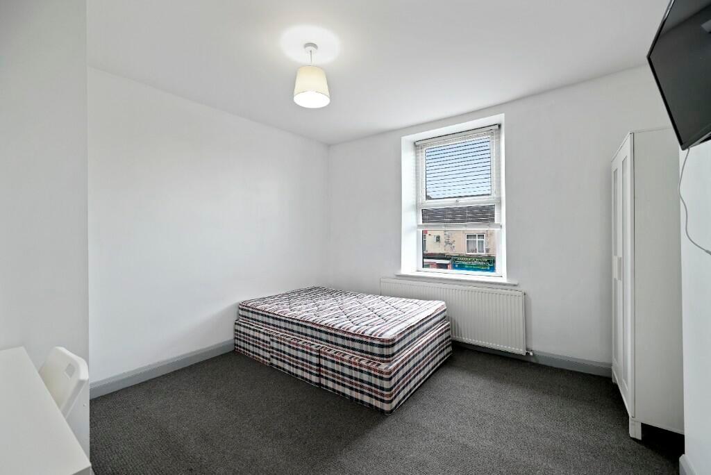 A clean and bright double bedroom featuring a l...