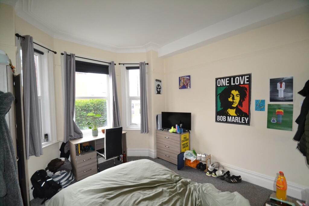A charming double bedroom featuring large windo...