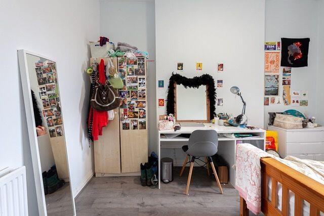 A bright and tidy room featuring a desk with a ...