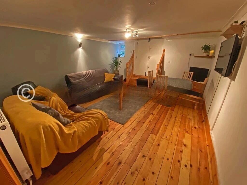 A cozy living room featuring warm wooden floori...