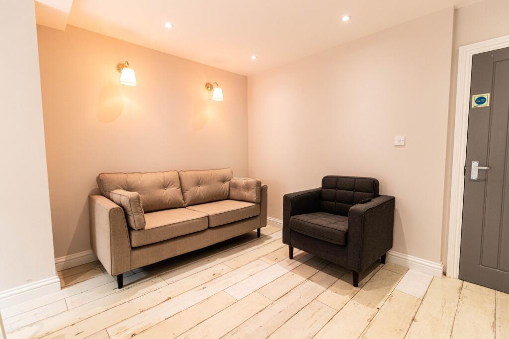 A modern, well-lit living room featuring a beig...