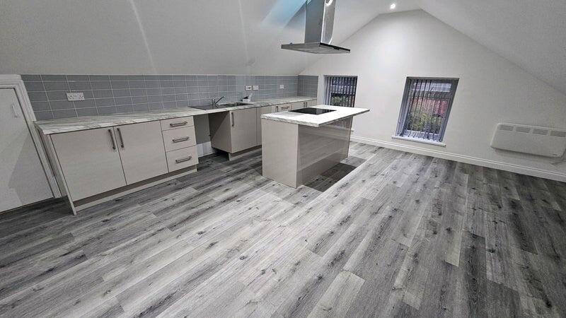 Bright modern open-plan kitchen with central is...
