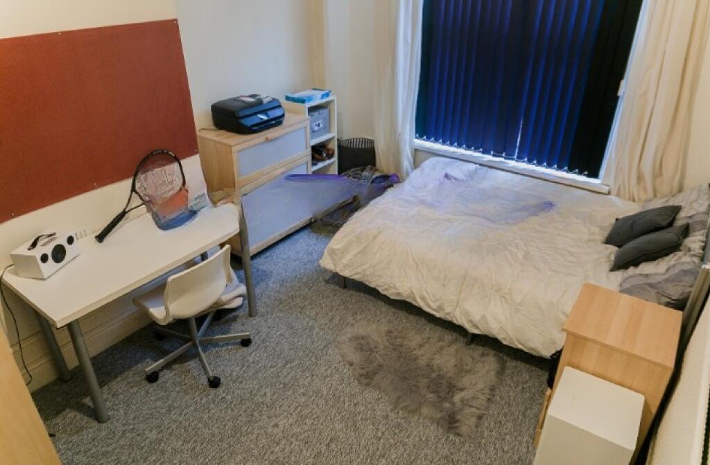 Cozy single bedroom featuring a comfortable bed...