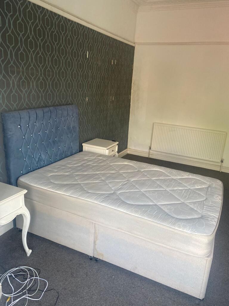 A spacious double bedroom featuring a stylish b...