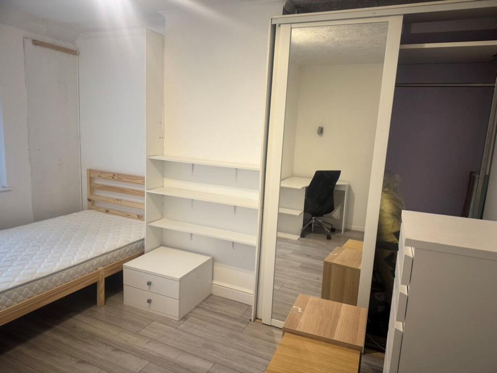 A spacious and tidy double bedroom featuring am...