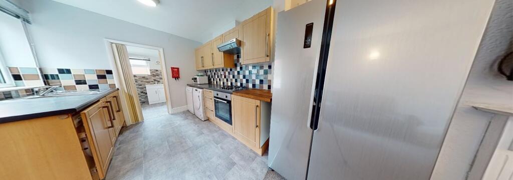 Bright and modern kitchen featuring wooden cabi...