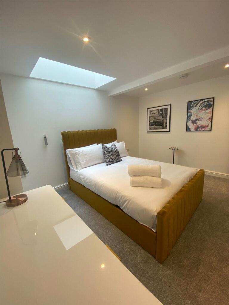 A spacious, bright master bedroom featuring a m...