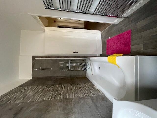 A modern bathroom featuring a spacious bathtub,...
