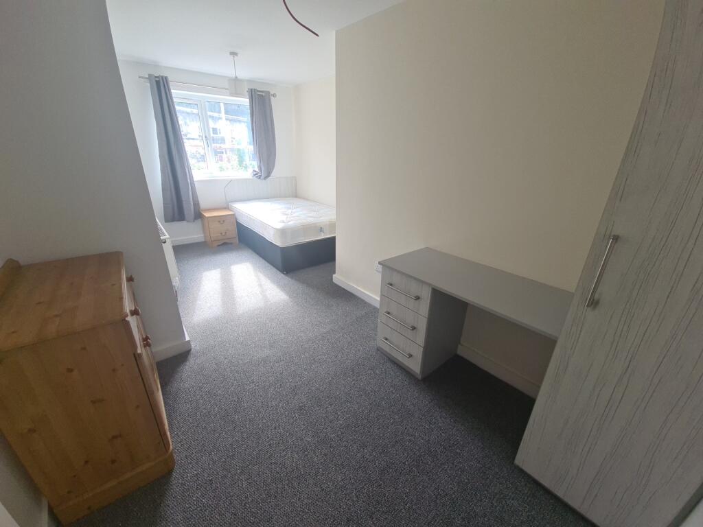 A tidy and well-lit single bedroom featuring a ...