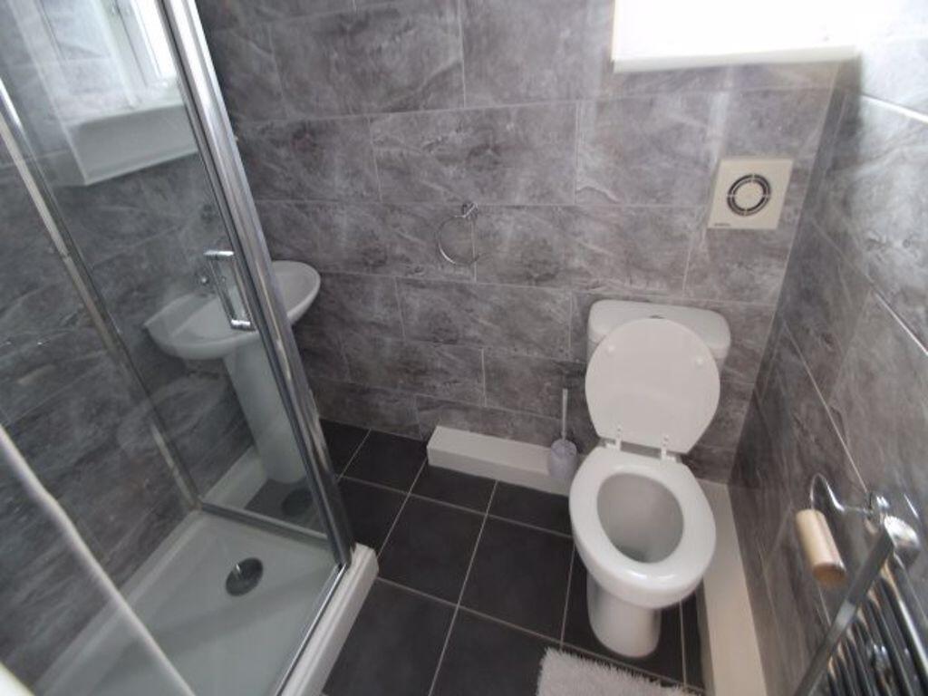 A modern bathroom featuring a glass-enclosed sh...