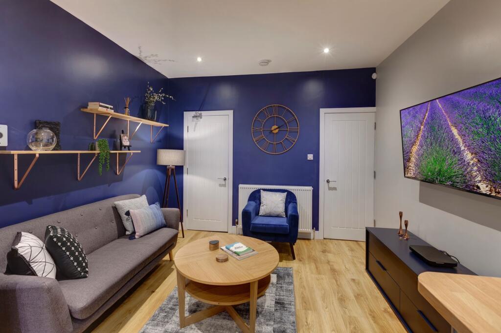 A modern, well-lit living room featuring a grey...