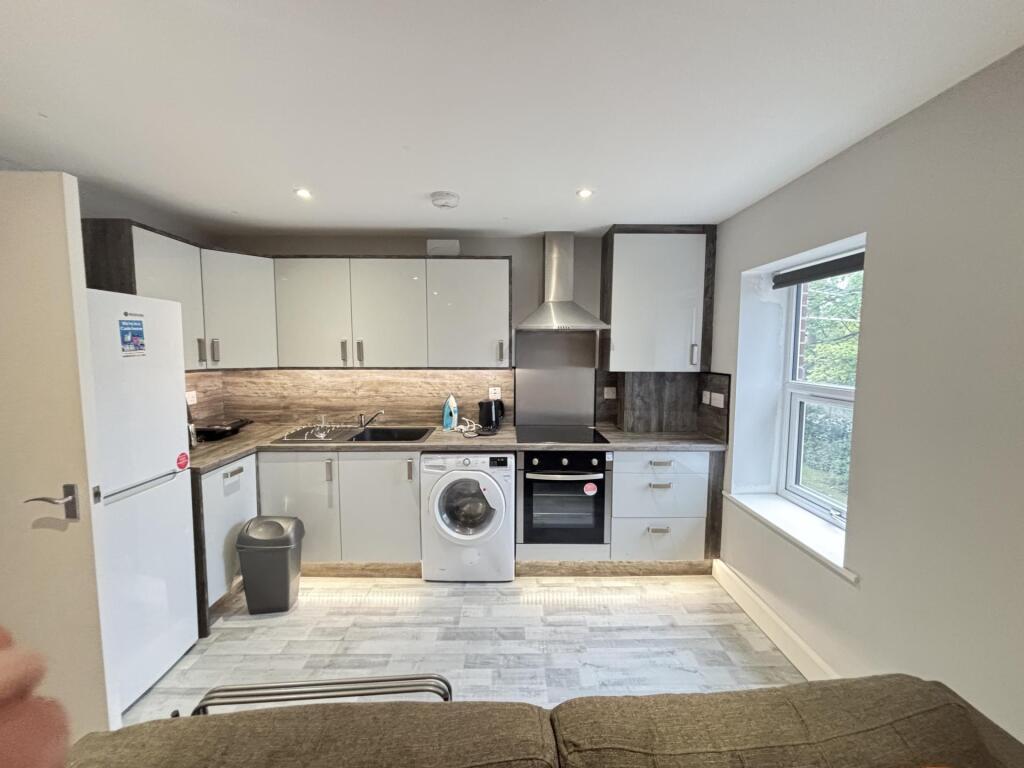 Bright, modern open-plan kitchen with integrate...