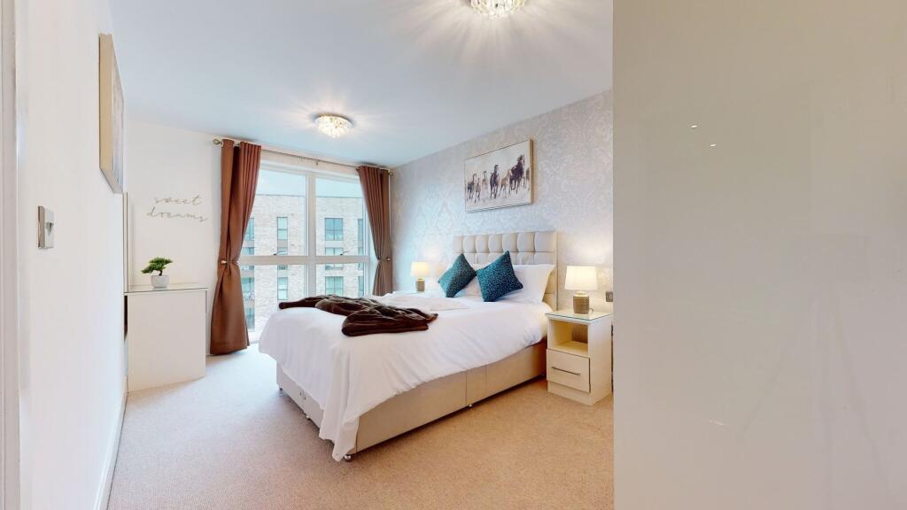 A modern master bedroom featuring a comfortable...