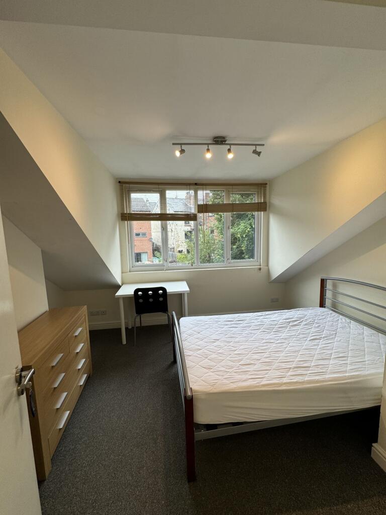 A bright, spacious master bedroom featuring a l...