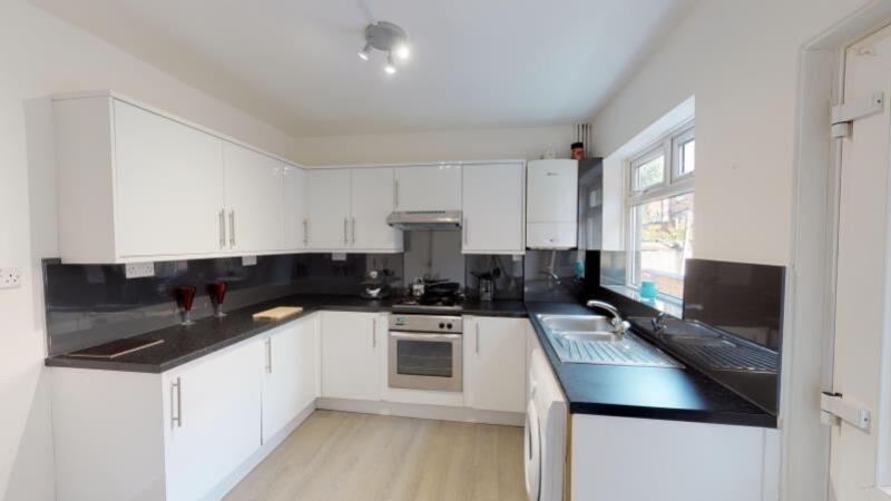 Bright and modern kitchen featuring white cabin...