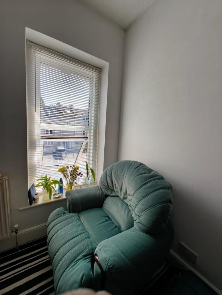 Cozy living space featuring a comfortable green...