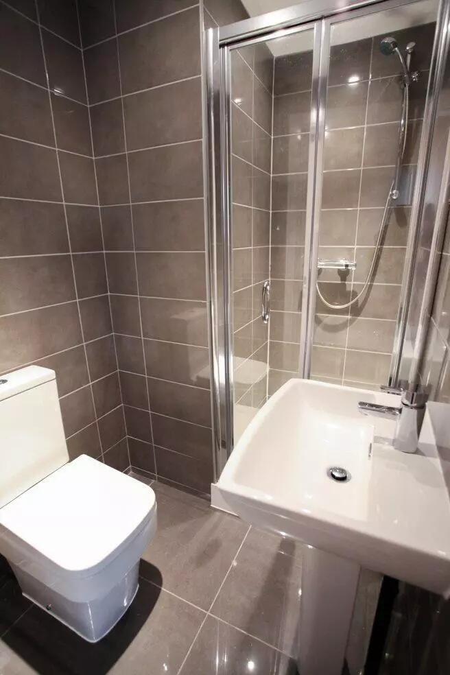 A modern bathroom featuring sleek grey tiles, a...